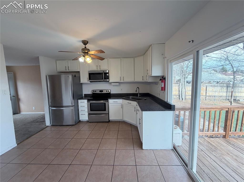 38 Macalester Road Pueblo, CO 81001 - Photo 7 of 15 a kitchen with granite countertop a refrigerator a sink a stove top oven and cabinets