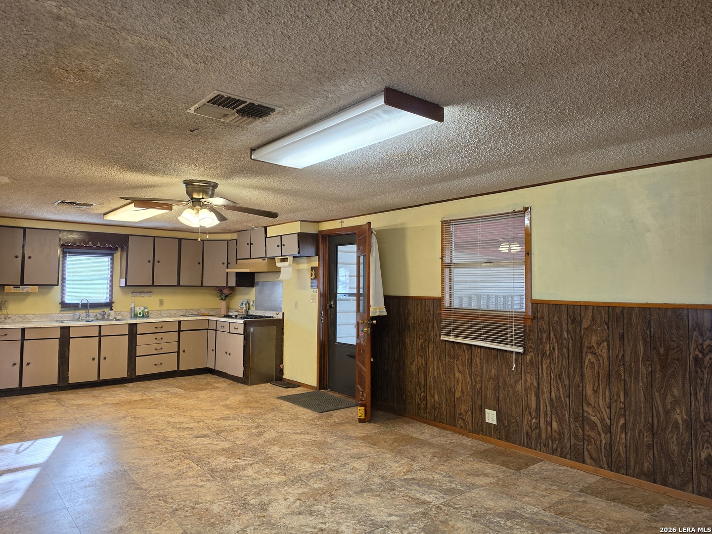 508 Nueces Cotulla, TX 78014 - Photo 8 of 14 a large kitchen with a stove refrigerator and wooden cabinets