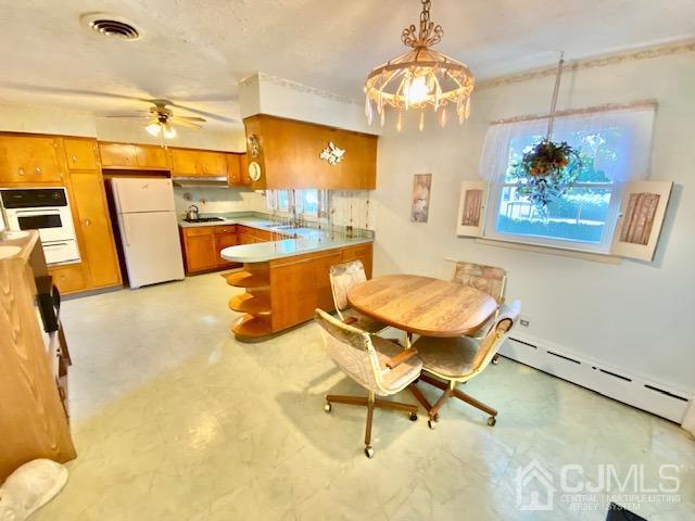 30 Main Street East Brunswick, NJ 08816 - Photo 14 of 40 a dining room with wooden floor and chandelier