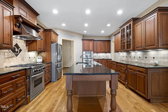 a kitchen with granite countertop a sink stove and cabinets