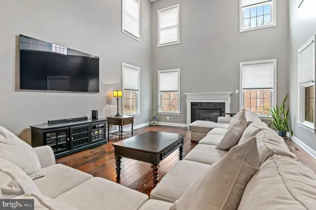 a kitchen with kitchen island granite countertop wooden floors and a view of living room