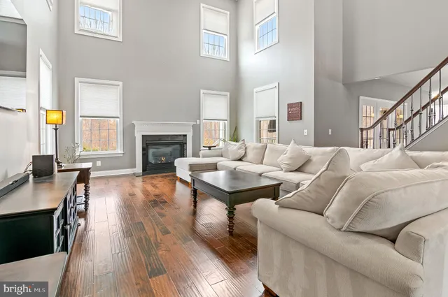 a kitchen with a sink a stove a refrigerator and white cabinets with wooden floor