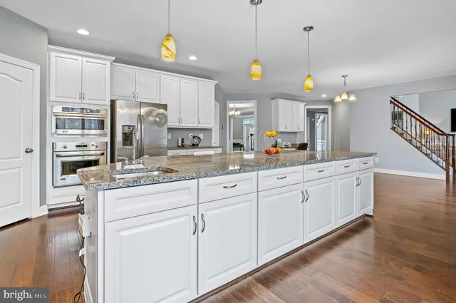 a view of a hallway with wooden floor and stairs