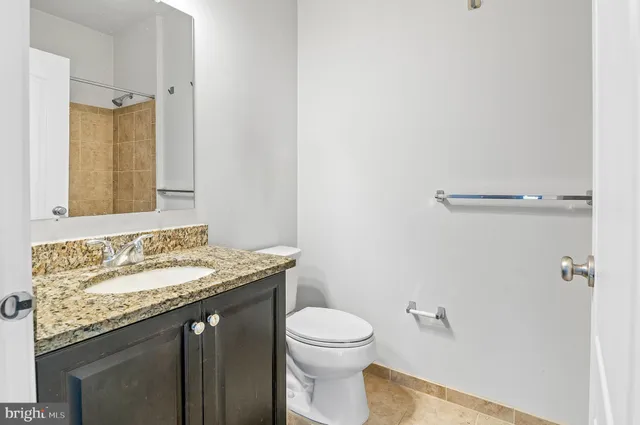 a living room with a couch and a chandelier with kitchen view