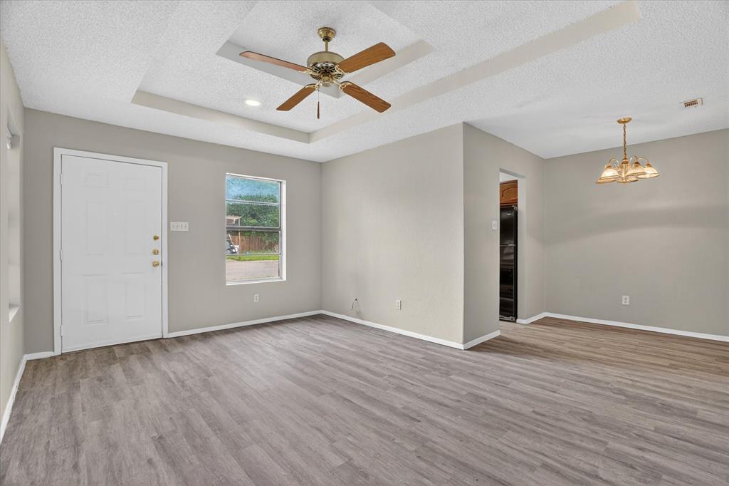 119 Del Rio Avenue, Unit C Benbrook, TX 76126 - Photo 4 of 17 a view of an empty room with wooden floor and a ceiling fan