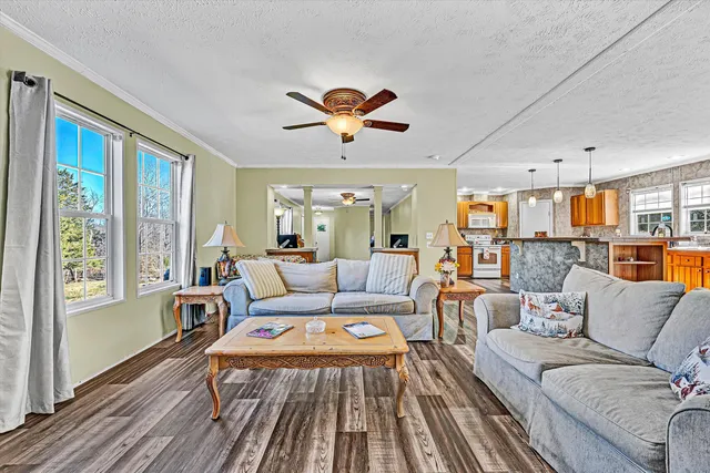 a kitchen with kitchen island granite countertop a stove a sink a center island and windows