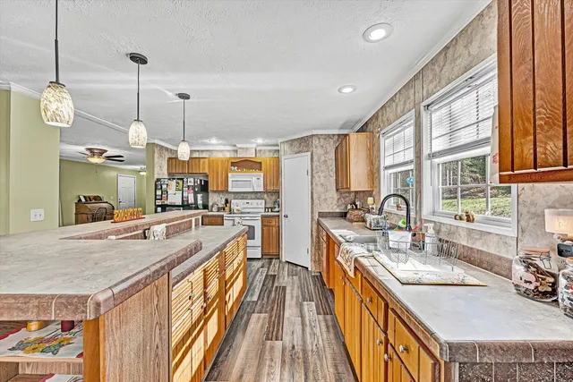 a kitchen with stainless steel appliances granite countertop a stove a sink dishwasher and cabinets with wooden floor
