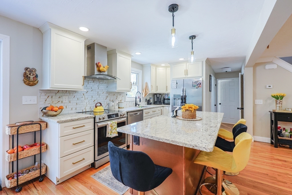 158 Chester Street Worcester, MA 01605 - Photo 13 of 42 a kitchen with a sink a stove and chairs with wooden floor