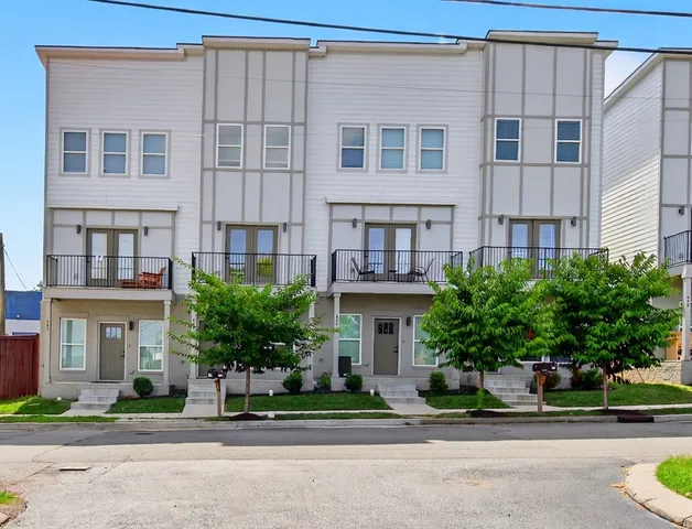 a front view of a building with a garden and plants