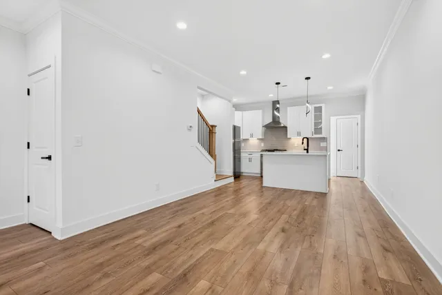 a view of a kitchen with wooden floor and electronic appliances