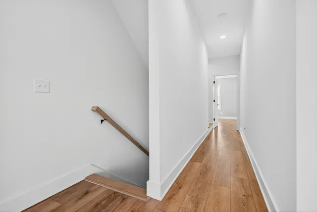 a view of a hallway with wooden floor