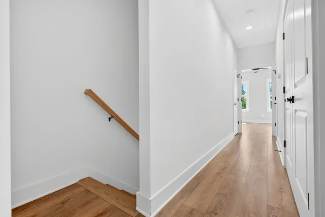 a view of a hallway with wooden floor and staircase