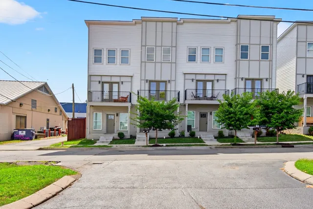 a front view of residential houses with yard and green space