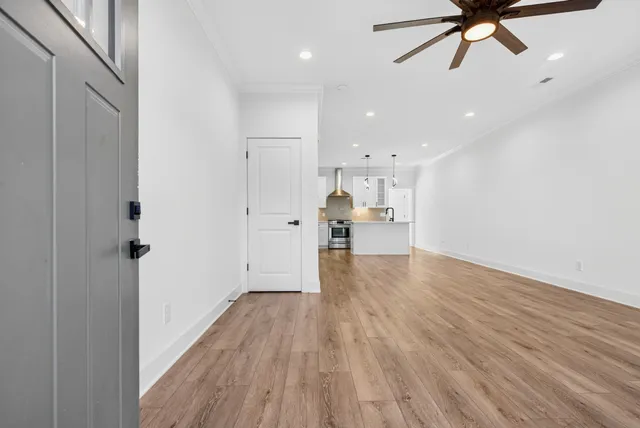 a view of empty room with wooden floor and ceiling fan