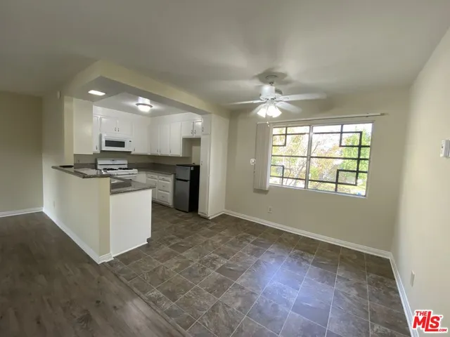 a view of kitchen with stove top oven and refrigerator