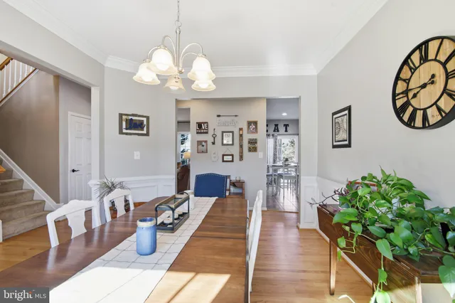 a living room with furniture a chandelier and a wooden floor