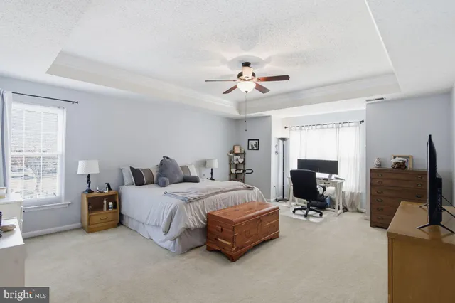 a spacious bedroom with a bed and a chandelier