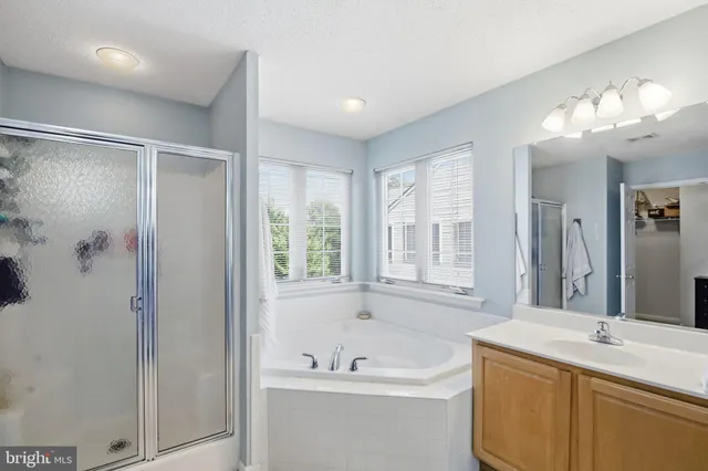a bathroom with a tub sink and mirror