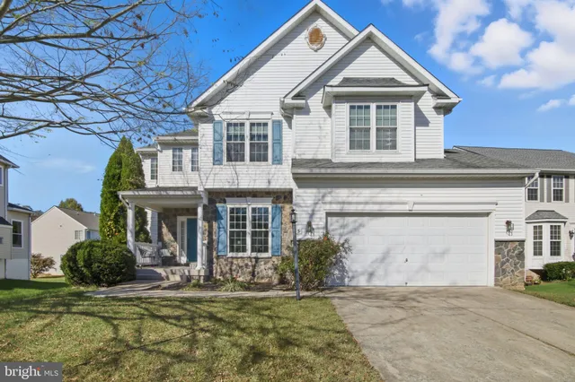 a view of a white house with large windows and a small yard