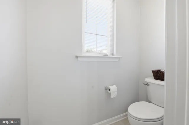 a white toilet sitting next to a window