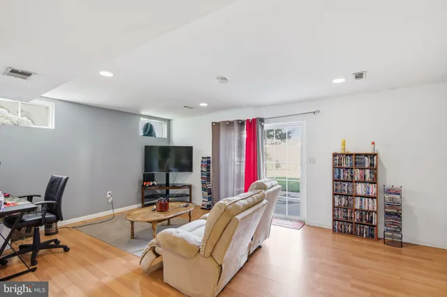 a living room with furniture a flat screen tv and a book shelf