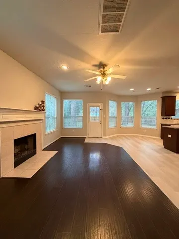 a view of a livingroom with a fireplace wooden floor and windows
