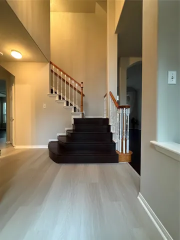a view of entryway and hall with wooden floor