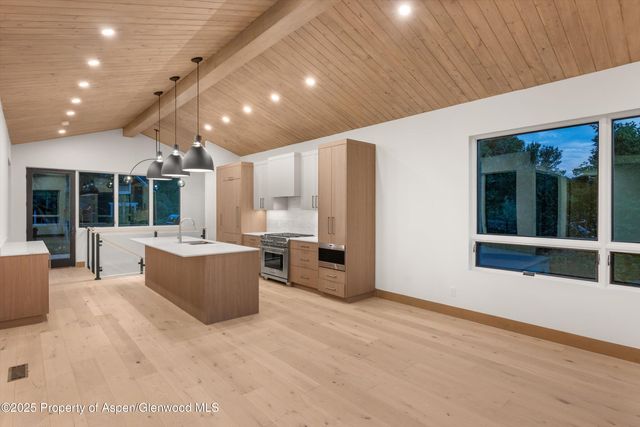a view of a big room with kitchen island stainless steel appliances wooden floor and living room view