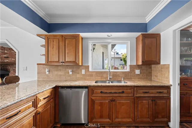 a kitchen with granite countertop a sink cabinets and stainless steel appliances
