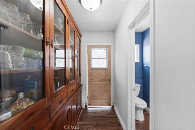 a view of a hallway with wooden floor and windows