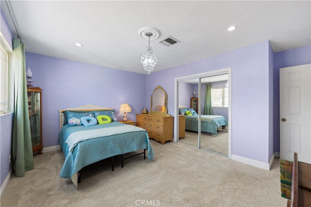 24405 Derian Drive Newhall, CA 91321 - Photo 20 of 36 a bedroom with a bed and a chandelier