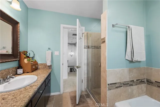 a bathroom with a granite countertop sink mirror and shower