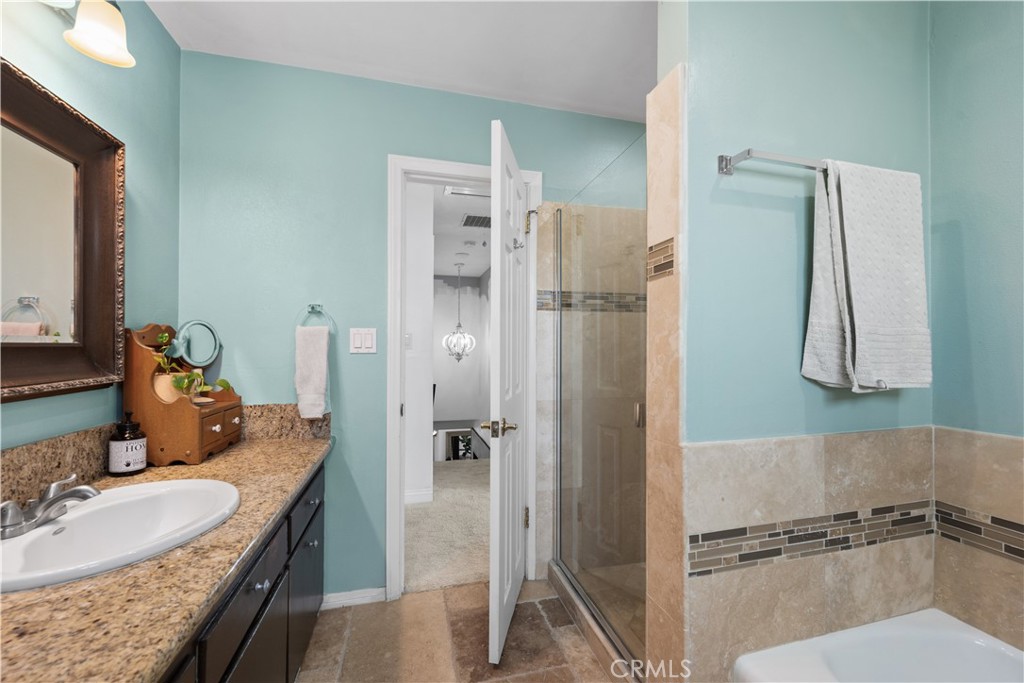 24405 Derian Drive Newhall, CA 91321 - Photo 21 of 36 a bathroom with a granite countertop sink mirror and shower