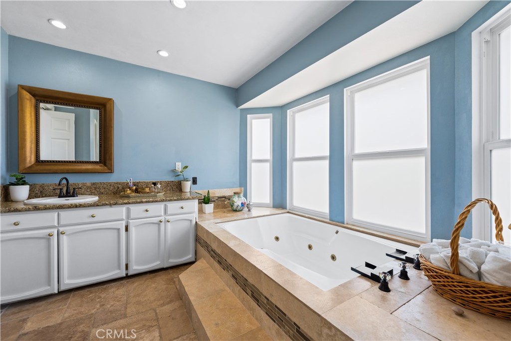 24405 Derian Drive Newhall, CA 91321 - Photo 27 of 36 a bathroom with a granite countertop tub sink and mirror