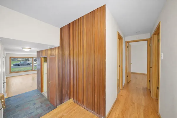 a view of a hallway with wooden floor and doors