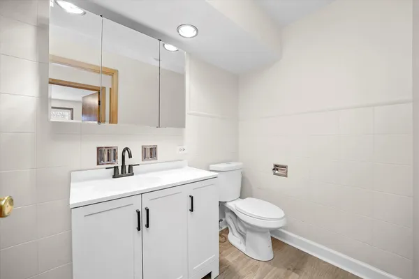 a bathroom with a toilet a sink and mirror