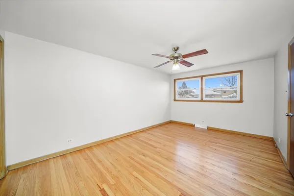 a view of a big room with wooden floor and a ceiling fan