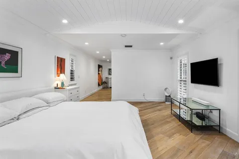 a bedroom with a bed and a flat screen tv