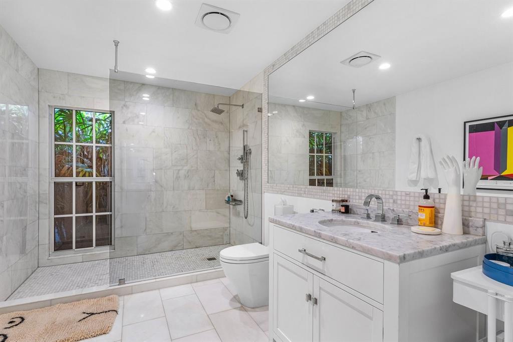 17844 Scarsdale Way Boca Raton, FL 33496 - Photo 19 of 38 a bathroom with a granite countertop sink a toilet a mirror and shower