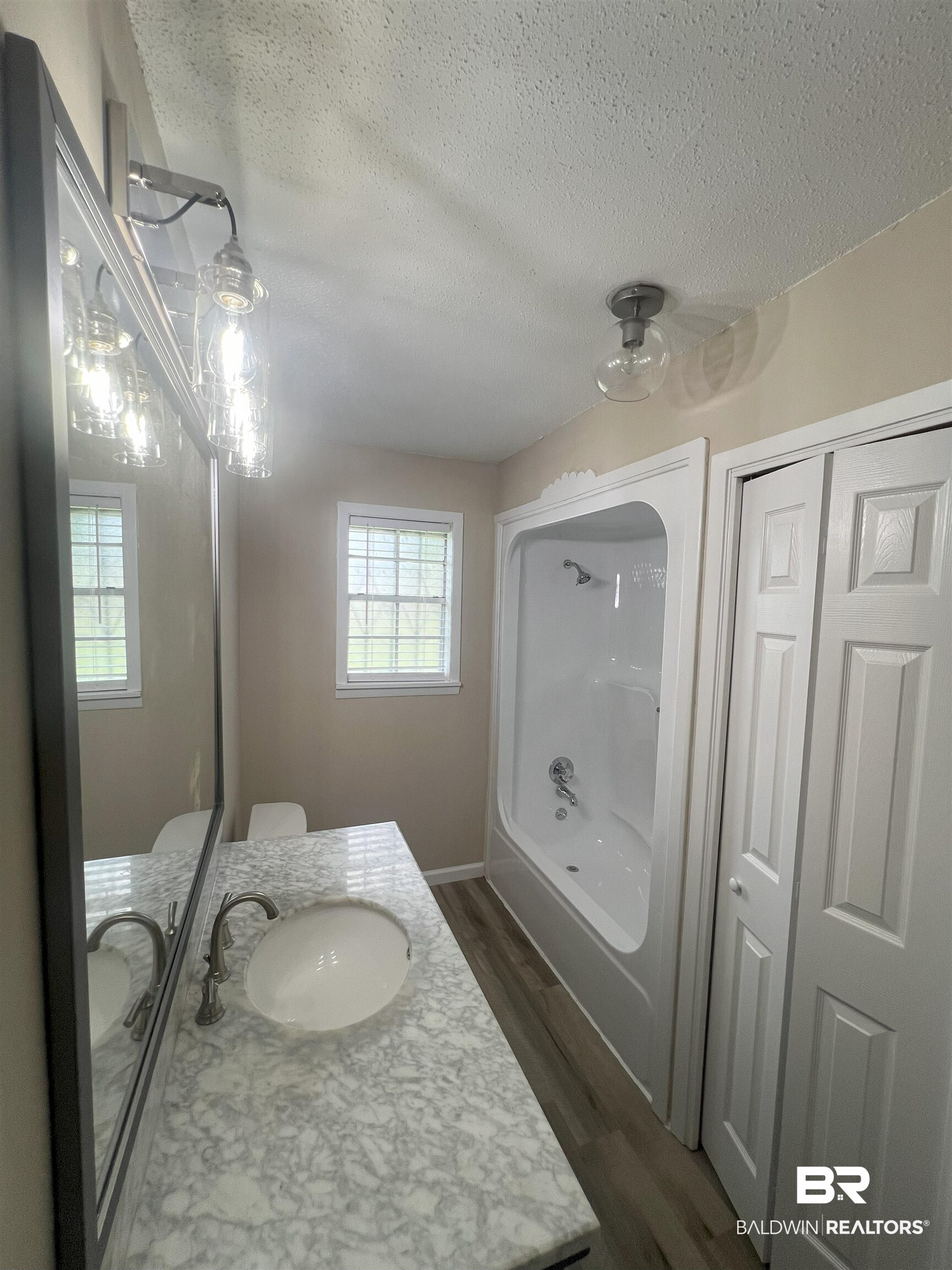 508 Freemanville Drive Atmore, AL 36502 - Photo 17 of 27 Bathroom featuring hardwood / wood-style floors, vanity, and a textured ceiling