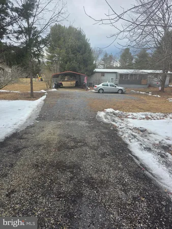 a view of a yard with a car parked in front of it