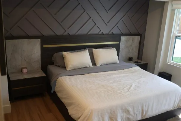 a bedroom with a bed and painting on the wall