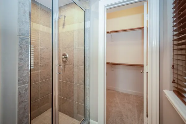 a bathroom with a glass shower door and a window