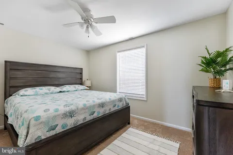 a bed sitting in a bedroom next to a window and a chandelier