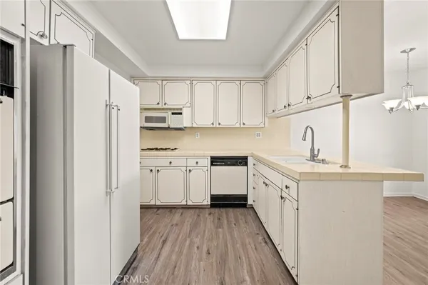 a view of kitchen with center island stainless steel appliances wooden floor and window