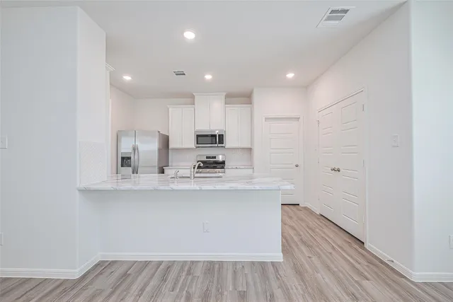 a kitchen with kitchen island a sink and a stove top oven