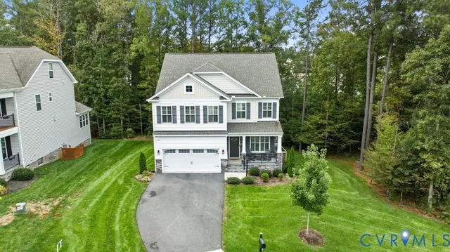 a view of a white house with a big yard and large tree