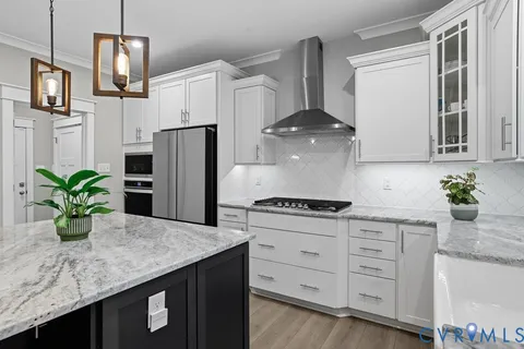 a kitchen with stainless steel appliances granite countertop a sink a refrigerator a stove a oven a counter space and cabinets