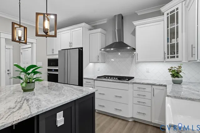 a kitchen with stainless steel appliances granite countertop a sink a refrigerator a stove a oven a counter space and cabinets