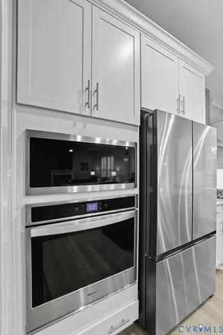 a metallic refrigerator freezer sitting in a kitchen